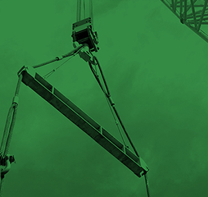 Crane is lifting the machine using spreader bar and sky background in a chemical factory.